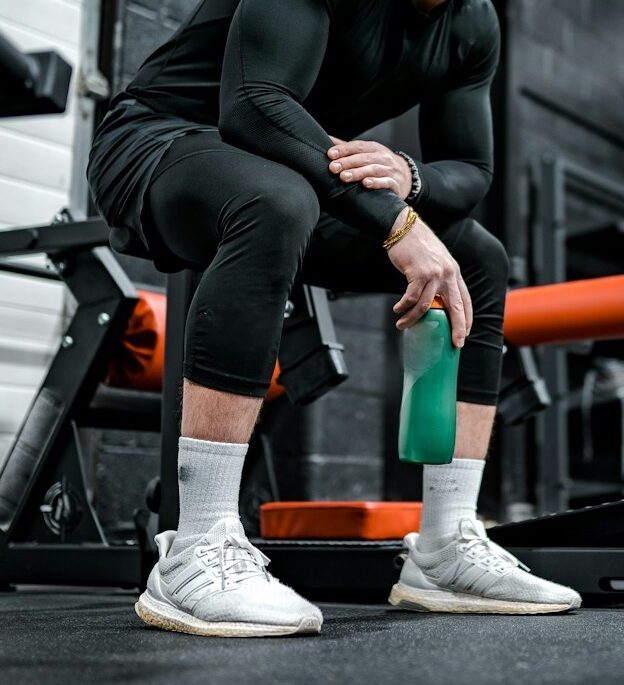 woman in black long sleeve shirt and black pants sitting on exercise equipment